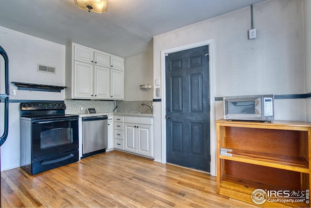 kitchen featuring appliances with stainless steel finishes, light wood-style floors, visible vents, and white cabinets