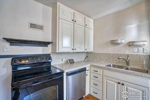 kitchen with stainless steel dishwasher, a sink, visible vents, and black electric range oven