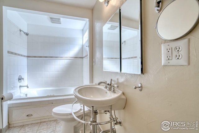bathroom featuring shower / bath combination, visible vents, toilet, tile patterned flooring, and a sink
