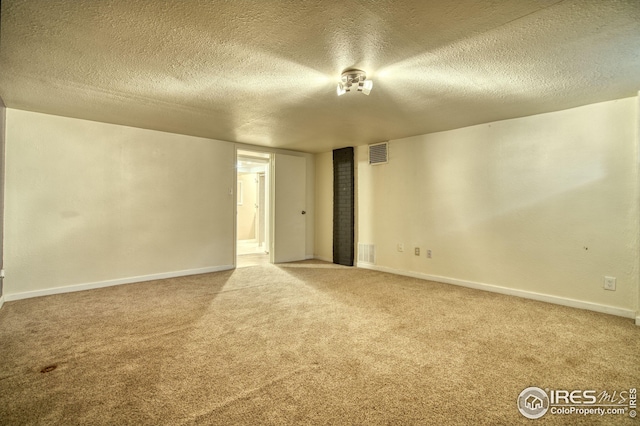 spare room featuring carpet, visible vents, and baseboards