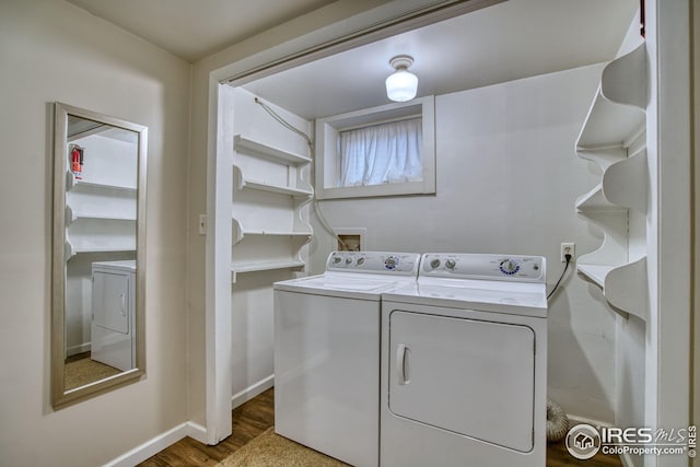 laundry area featuring dark wood-style floors, laundry area, washer and clothes dryer, and baseboards