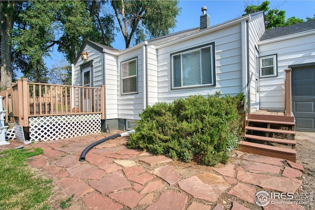 view of home's exterior featuring a chimney and a wooden deck