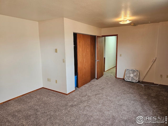 carpeted empty room with a textured ceiling