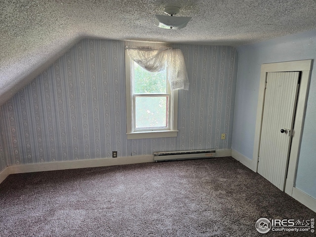 additional living space featuring a baseboard radiator, carpet floors, and a textured ceiling