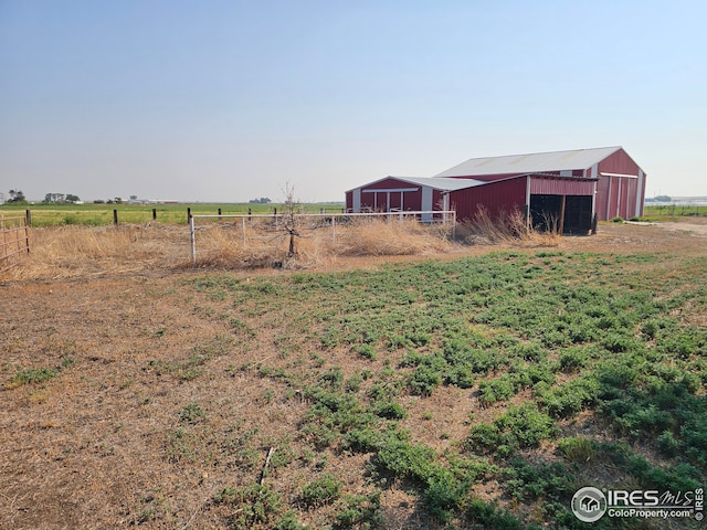 view of yard featuring a rural view and an outdoor structure