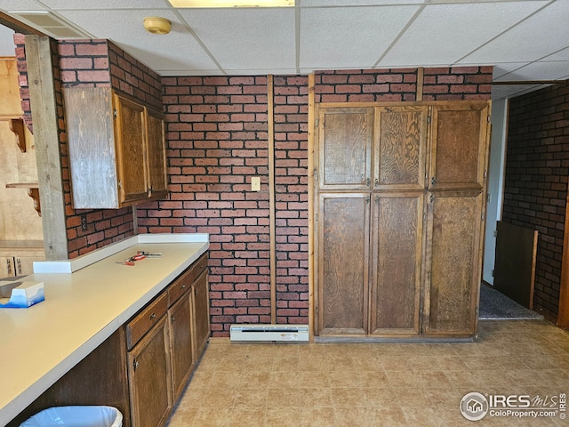 kitchen with brick wall and a paneled ceiling