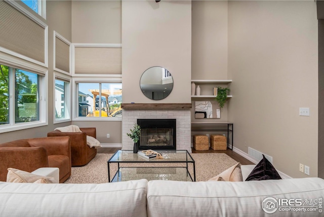 living room featuring a towering ceiling and a fireplace