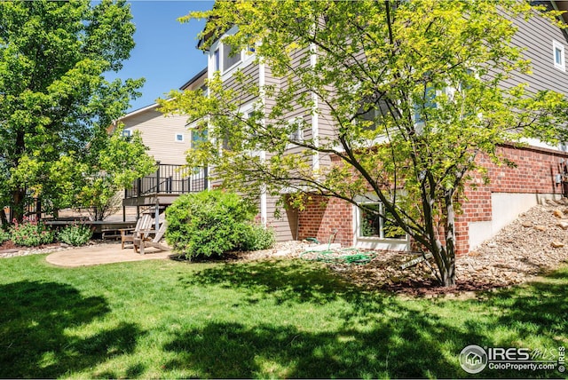 view of side of property featuring a lawn and a deck