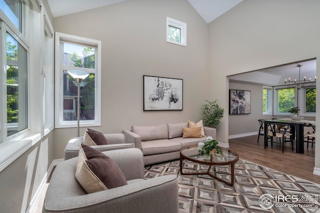 living room featuring an inviting chandelier, a healthy amount of sunlight, and hardwood / wood-style floors