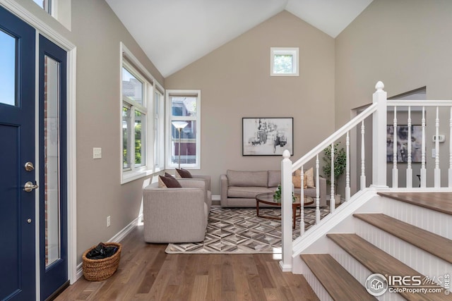 entrance foyer with hardwood / wood-style flooring, high vaulted ceiling, and plenty of natural light