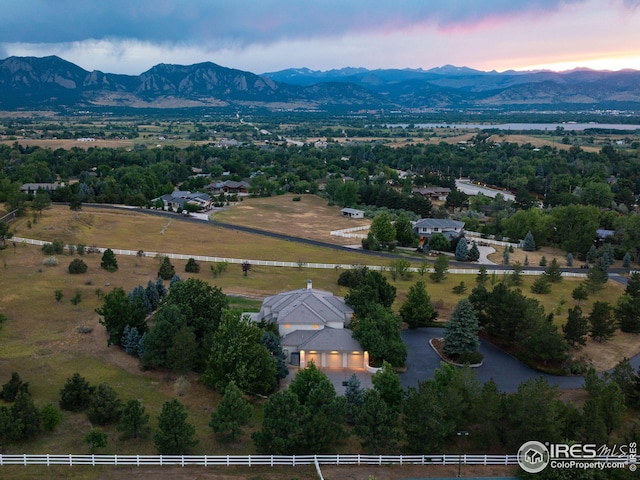 aerial view at dusk featuring a rural view and a mountain view