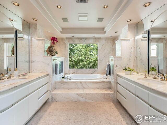 bathroom featuring a wealth of natural light, vanity, and a raised ceiling