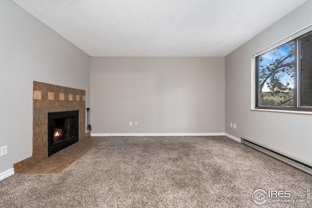 unfurnished living room featuring a fireplace, a textured ceiling, carpet flooring, and a baseboard radiator