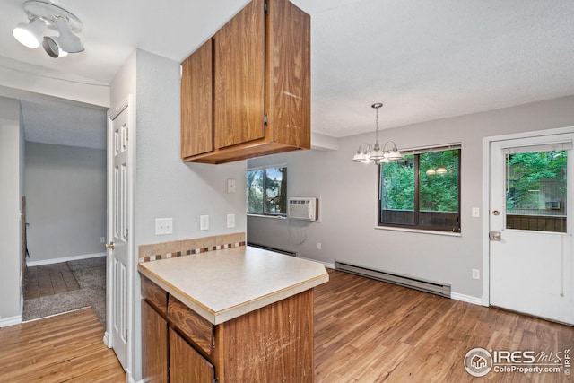 kitchen featuring decorative light fixtures, a notable chandelier, light hardwood / wood-style floors, and a baseboard radiator