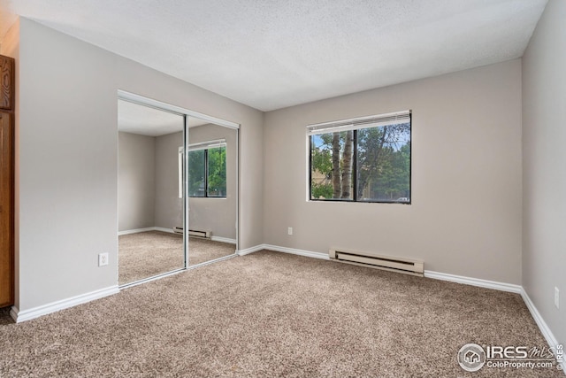 unfurnished bedroom featuring a closet, a textured ceiling, carpet floors, and a baseboard radiator