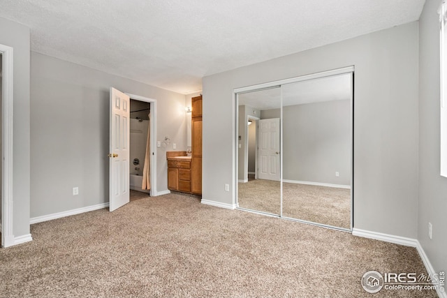 unfurnished bedroom featuring a textured ceiling, carpet flooring, and sink