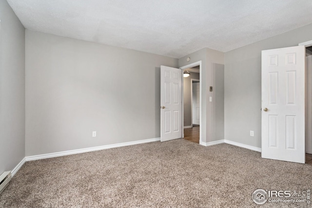 unfurnished bedroom featuring baseboard heating, a textured ceiling, and dark colored carpet