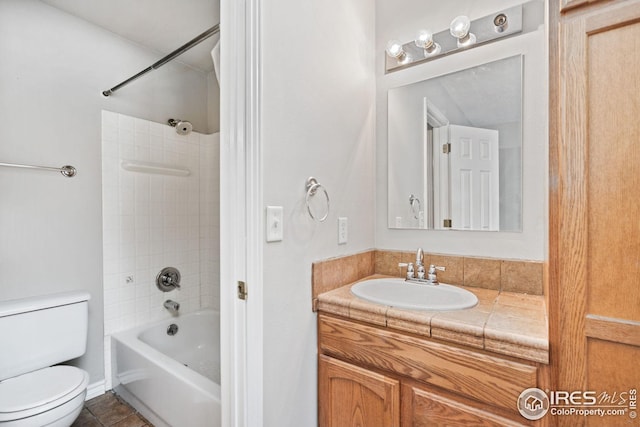 full bathroom featuring tile patterned flooring, vanity, toilet, and tiled shower / bath combo