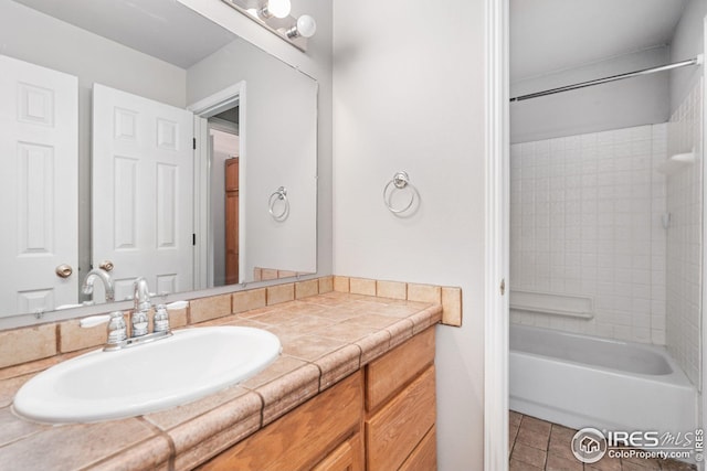 bathroom featuring tiled shower / bath combo, vanity, and tile patterned floors