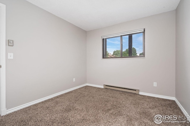 carpeted spare room with a textured ceiling and a baseboard heating unit