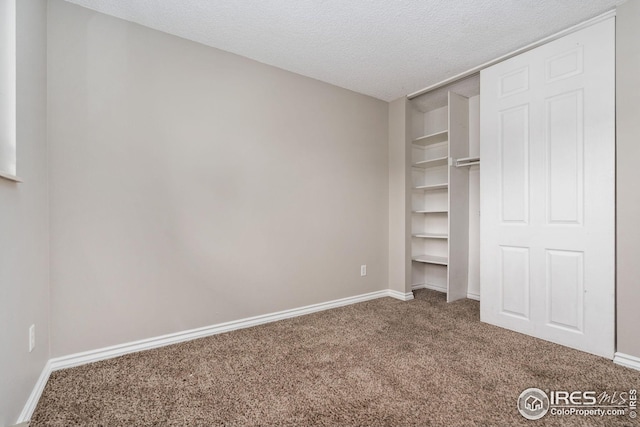 unfurnished bedroom featuring a closet, a textured ceiling, and carpet floors