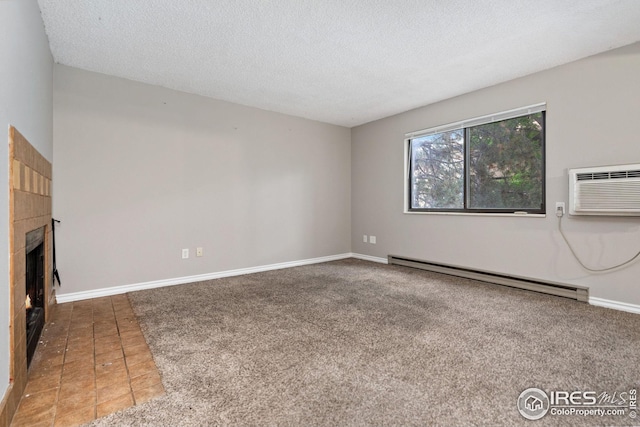 unfurnished living room with carpet, a textured ceiling, a tiled fireplace, a wall mounted air conditioner, and a baseboard heating unit