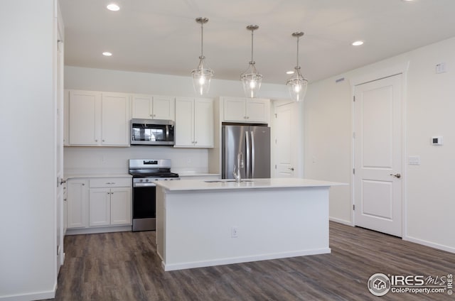 kitchen with dark wood-style floors, appliances with stainless steel finishes, an island with sink, and white cabinetry