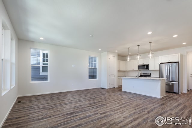 kitchen with dark wood-style floors, stainless steel appliances, light countertops, and white cabinets