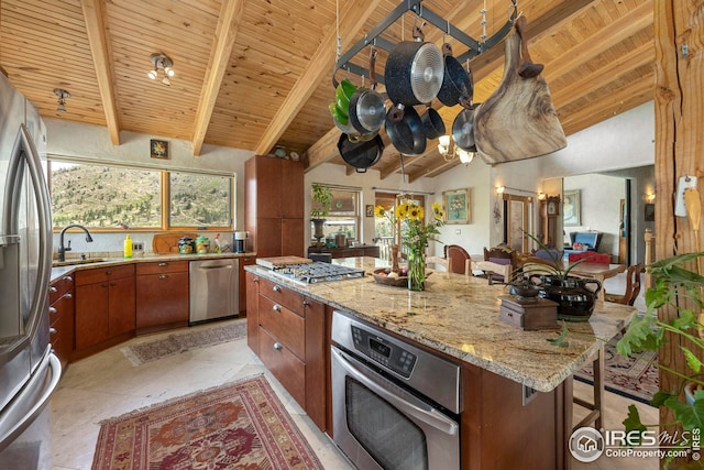 kitchen with wood ceiling, a kitchen island, vaulted ceiling with beams, stainless steel appliances, and a sink