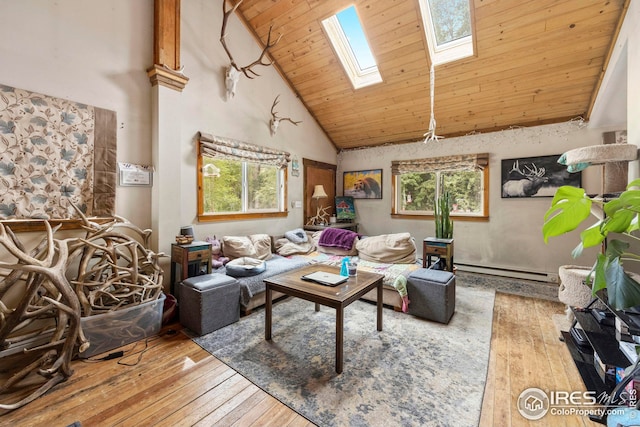 living area with a skylight, plenty of natural light, hardwood / wood-style floors, and a baseboard radiator