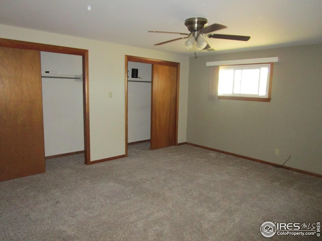 unfurnished bedroom with ceiling fan, carpet flooring, and multiple closets