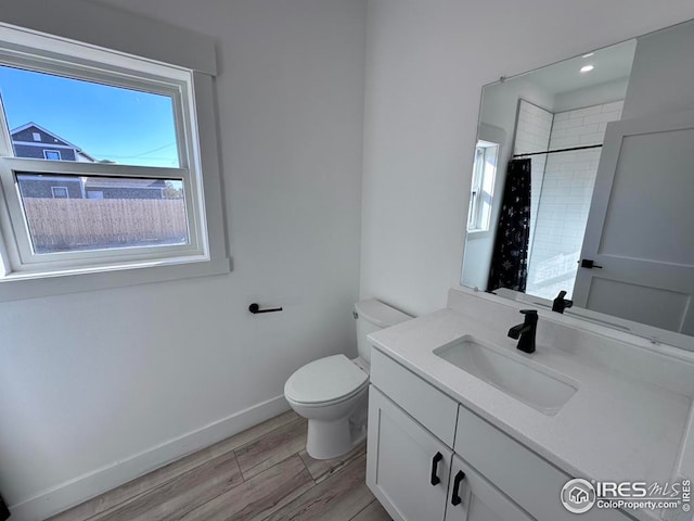 bathroom featuring vanity, wood-type flooring, toilet, and walk in shower