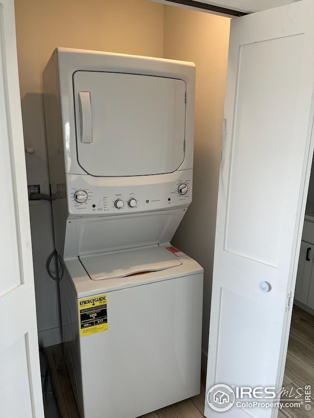 washroom featuring light hardwood / wood-style flooring and stacked washer / drying machine