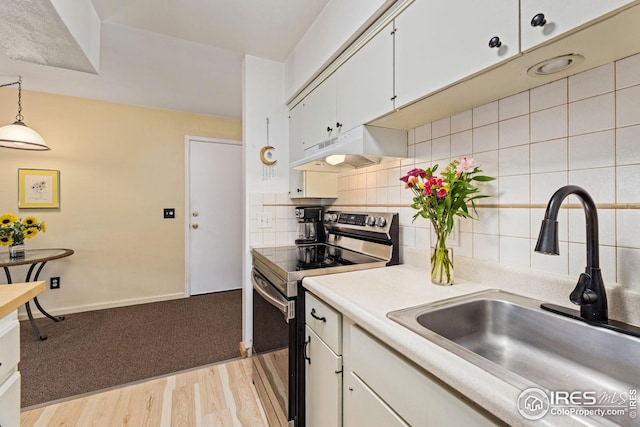 kitchen with light wood-type flooring, electric range, tasteful backsplash, exhaust hood, and sink