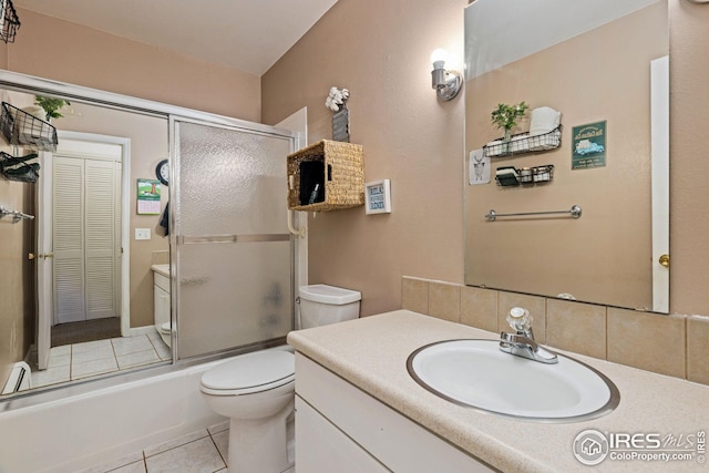 full bathroom featuring toilet, combined bath / shower with glass door, tile patterned flooring, and vanity