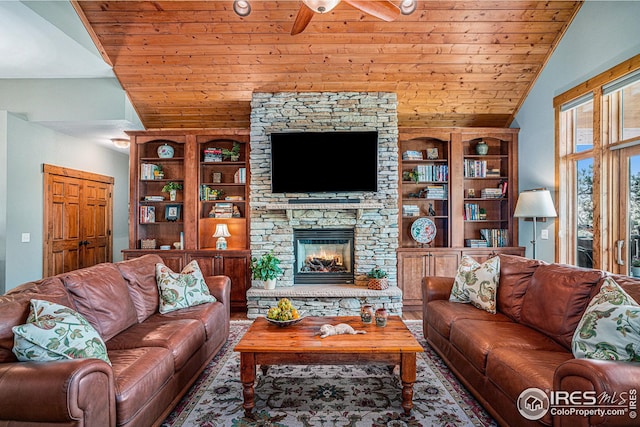 living room with built in features, wood ceiling, vaulted ceiling, and a stone fireplace