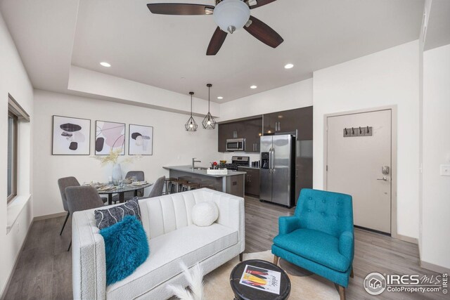 living area featuring a ceiling fan, visible vents, light wood finished floors, and recessed lighting