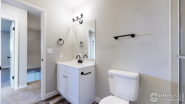 bathroom with hardwood / wood-style flooring, vanity, a baseboard heating unit, and toilet