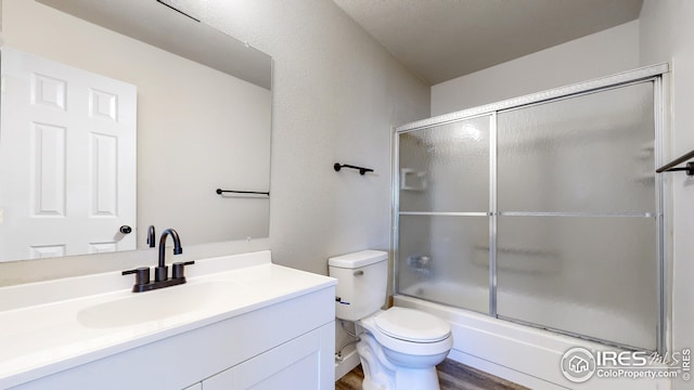 full bathroom featuring hardwood / wood-style flooring, toilet, vanity, and combined bath / shower with glass door