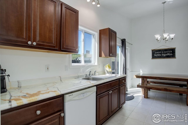 kitchen featuring hanging light fixtures, light tile patterned floors, white dishwasher, an inviting chandelier, and sink