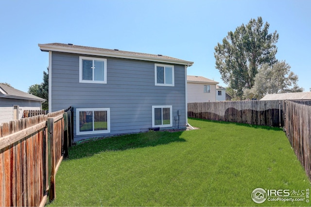 rear view of house with a yard