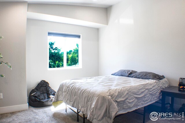 carpeted bedroom with lofted ceiling