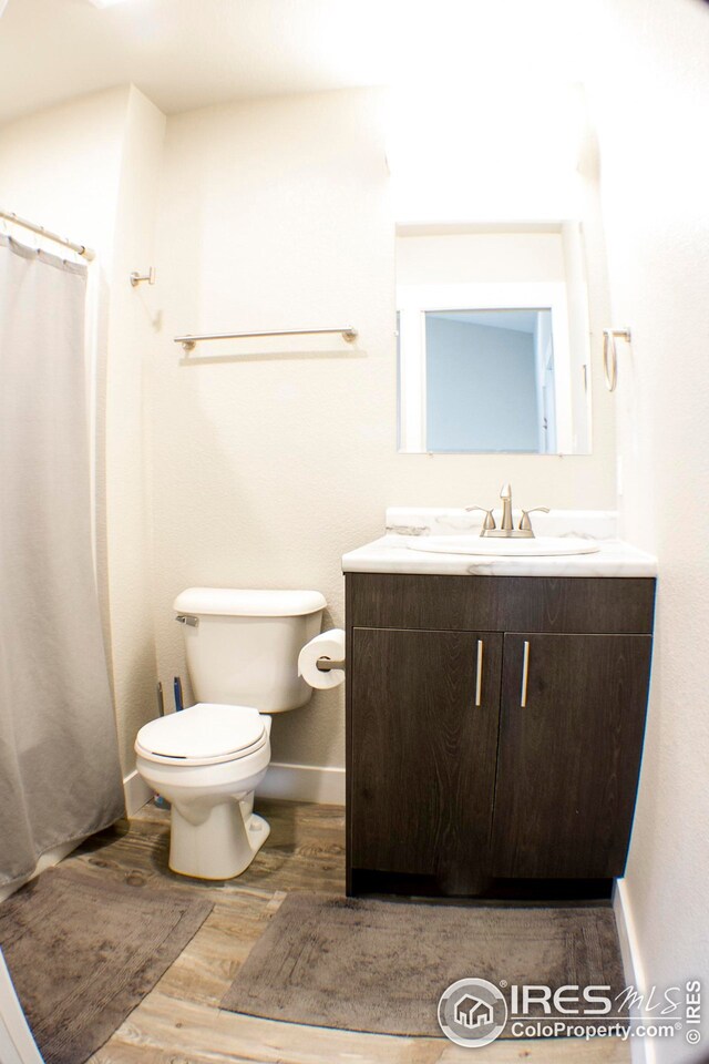 bathroom featuring hardwood / wood-style floors, toilet, and vanity