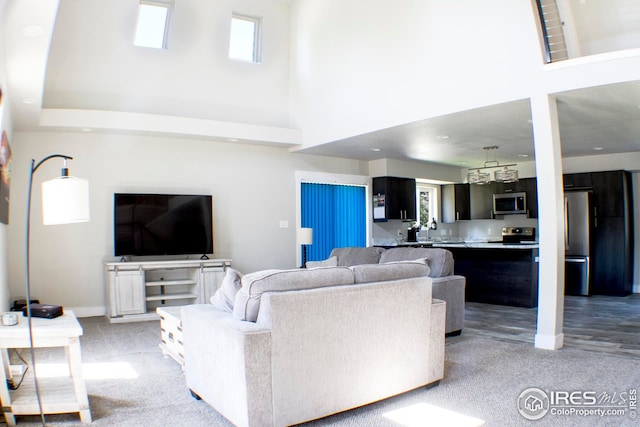 carpeted living room featuring a wealth of natural light and a high ceiling