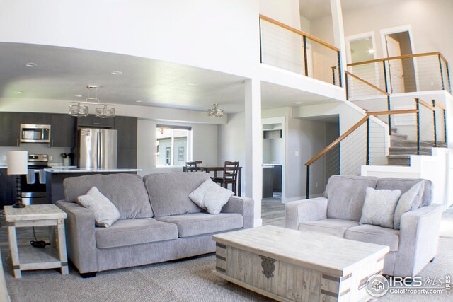 carpeted living room featuring a towering ceiling