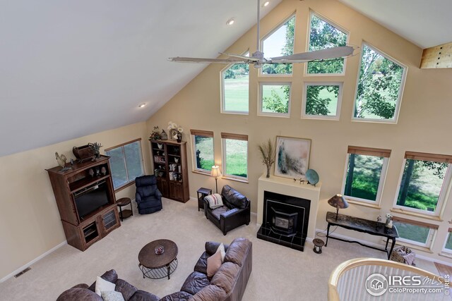 carpeted living room featuring high vaulted ceiling and ceiling fan