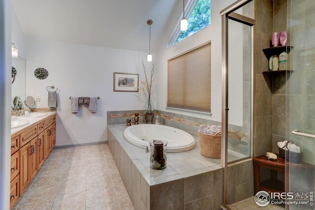 bathroom featuring tile patterned floors, vaulted ceiling, vanity, and shower with separate bathtub