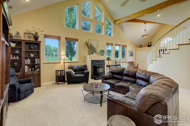 living room with carpet flooring, ceiling fan, beamed ceiling, and high vaulted ceiling