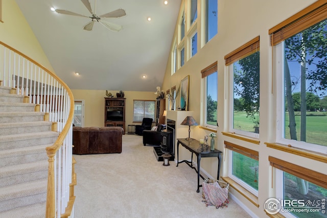 carpeted living room featuring high vaulted ceiling, plenty of natural light, and ceiling fan