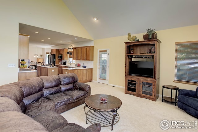 carpeted living room featuring sink and high vaulted ceiling